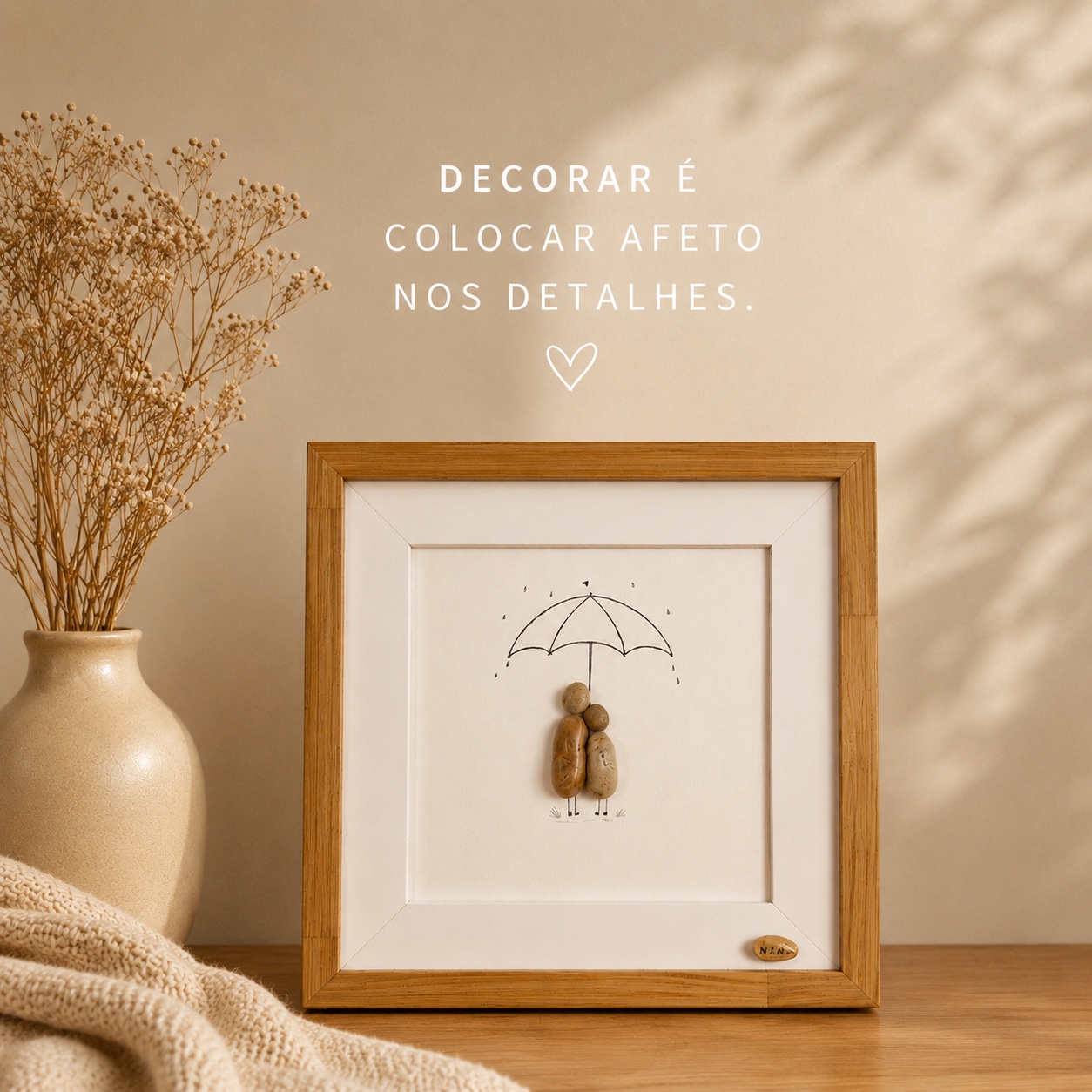 Quadro artesanal de casal em seixos sob um guarda-chuva